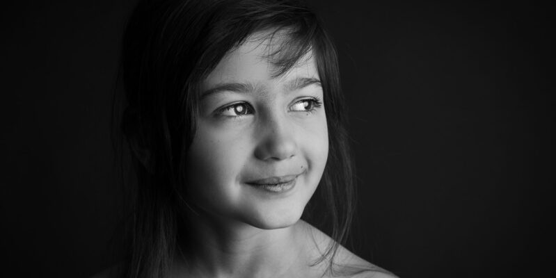 Kleiners Mädchen - Portrait auf schwarzem Hintergrund
