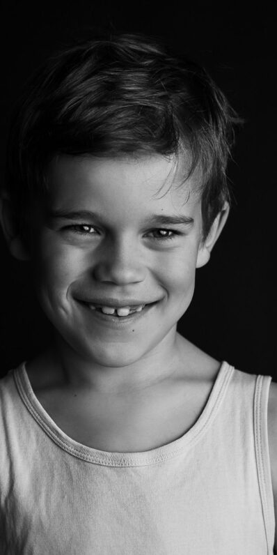 Kleiner Junge - Portrait auf schwarzem Hintergrund