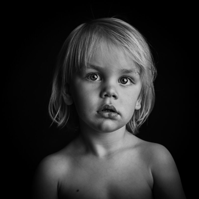 Kleiner Junge - Portrait auf schwarzem Hintergrund